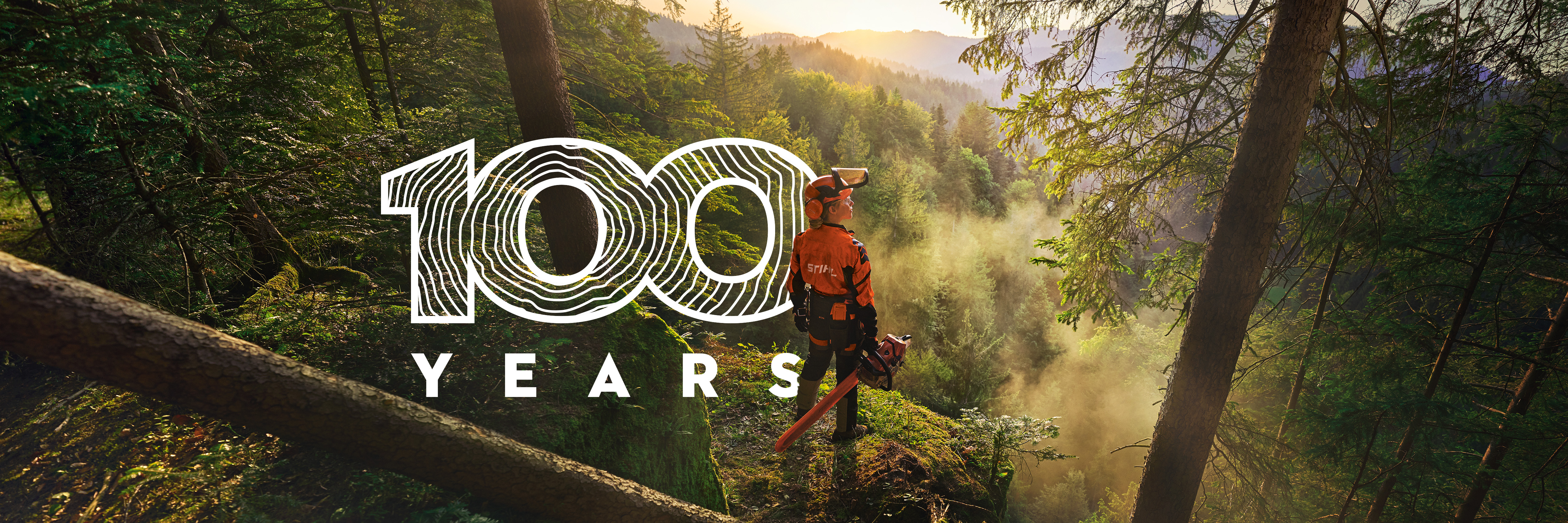 Baner promo për 100-vjetorin e kompanisë STIHL. Profesionisti STIHL në pyll me sharrë motorike dhe logon e 100-vjetorit.