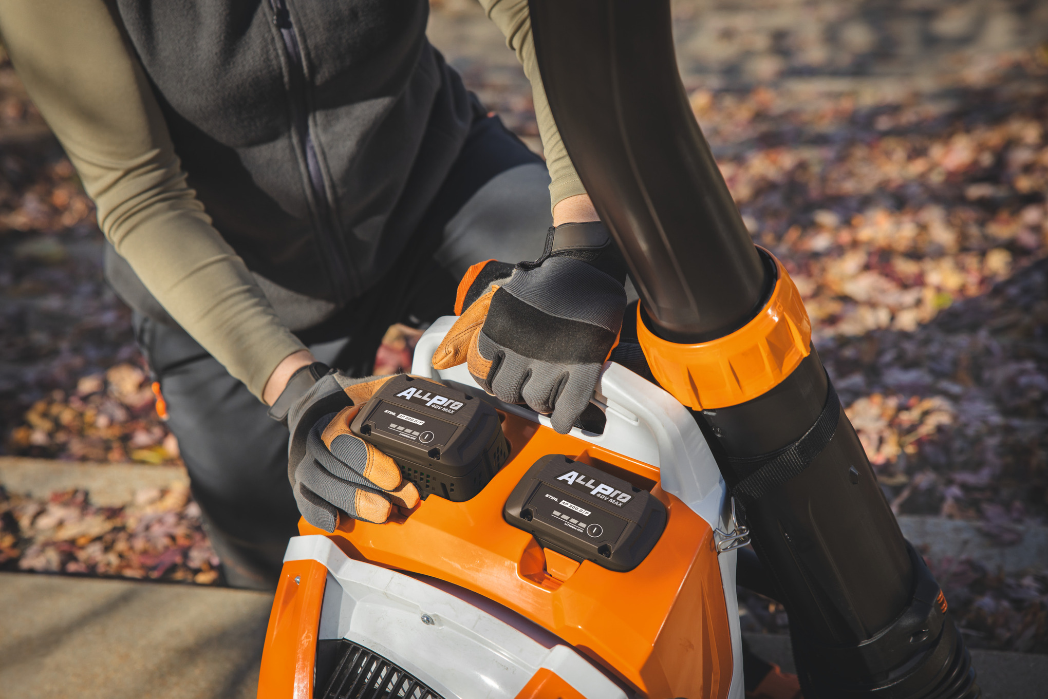 Profesionalni pejzažni voditelj postavlja dve kutije Stihl AP 300.0 P u ruksak za rukavice Stihl