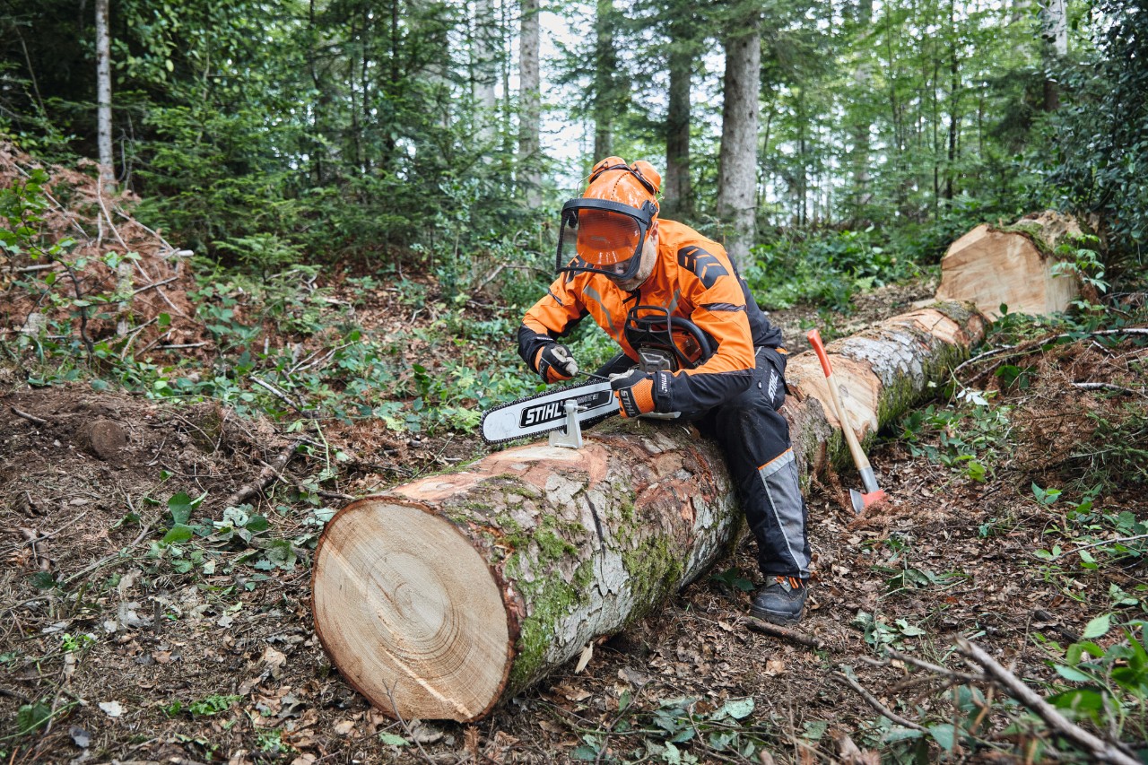 Čovek u zaštitnoj opremi seče već oboreno drvo pomoću STIHL lančane tastere sa punom vodilicom