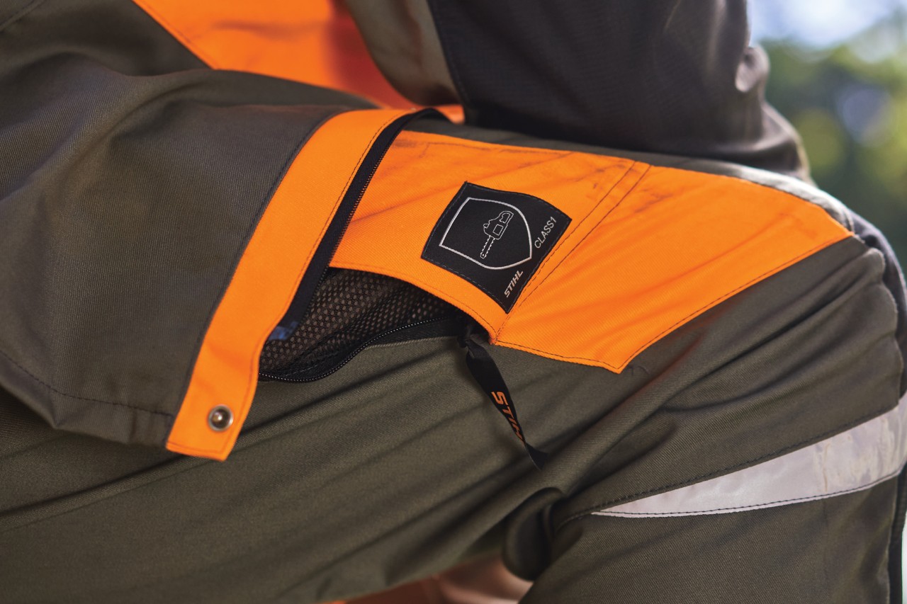 Sivo-narandžaste STIHL zaštitne pantalone sa piktogramom motorne testere za klasu zaštite od prosecanja 1