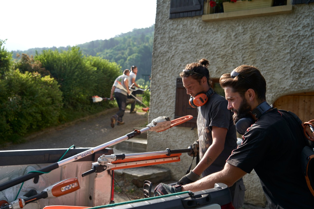 Julien Lokuarelli, pejzažni baštovan, istovara STIHL opremu iz vozila zajedno sa svojim kolegama.