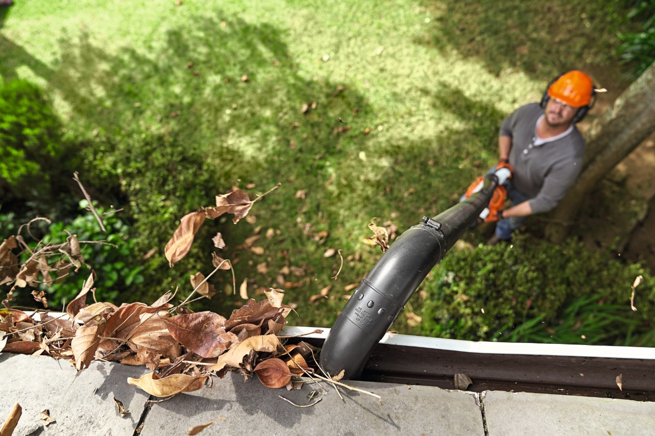 Muškarac čisti oluke STIHL setom za čišćenje oluka