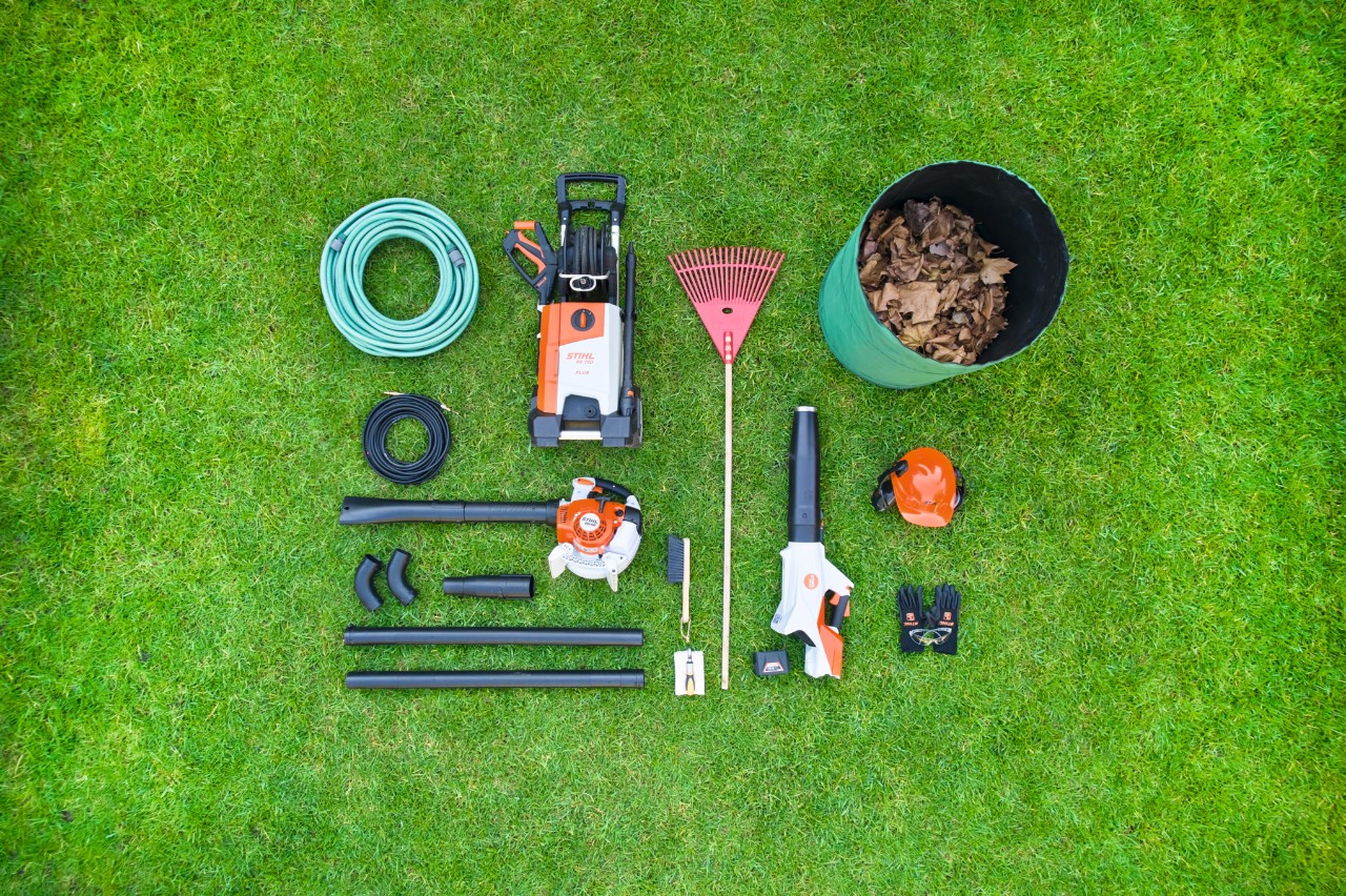Pojedinačni delovi STIHL kompleta za čišćenje oluka su uredno raspoređeni jedan pored drugog na travnjaku 