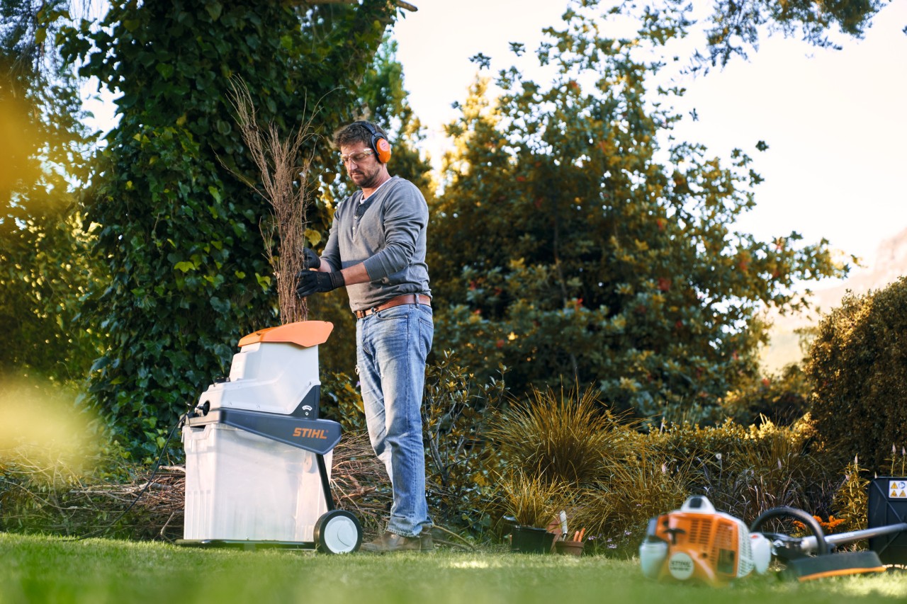 Muškarac sa STIHL usitnjivačem u bašti