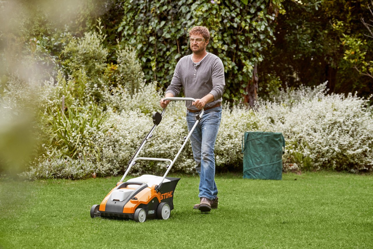 Muškarac prozračuje travnjak uz pomoć STIHL baterijskog prozračivača travnjaka RLA 240