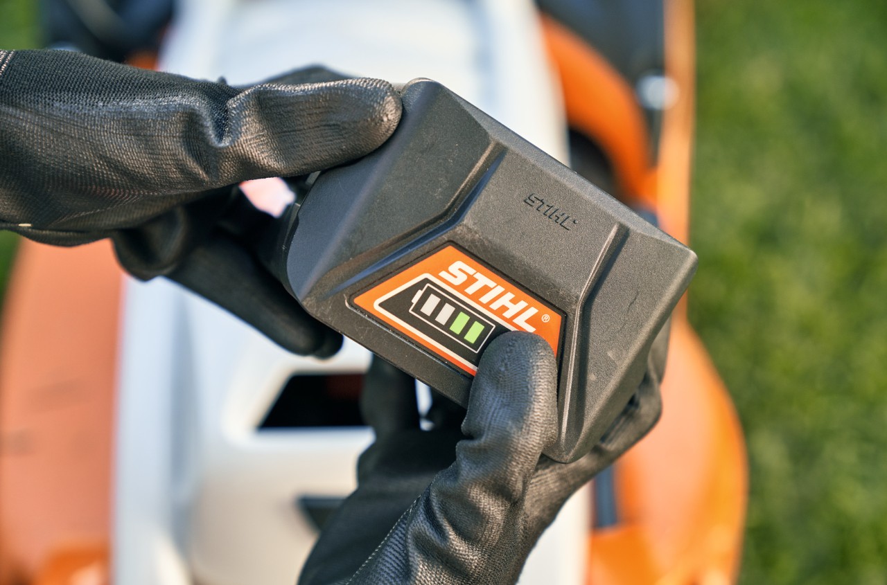 STIHL litijum-jonski akumulator, u pozadini akumulatorska kosačica STIHL RMA 339 C