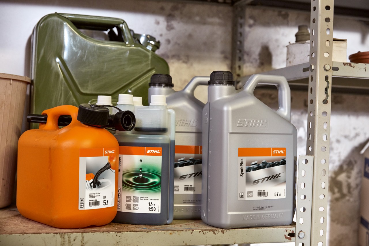Svetli kanister sa STIHL HP Super za dvotaktne motore i narandžasti kanister sa mešavinom za motornu kosu