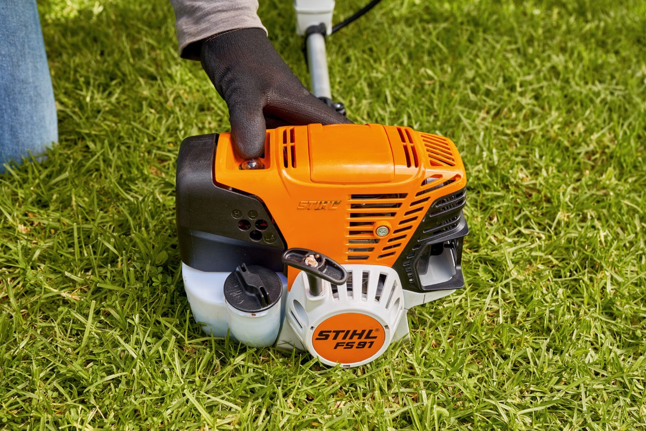 Čovek pritiska pumpu za gorivo benzinske motorne kose STIHL FS 91 kako bi je pokrenuo