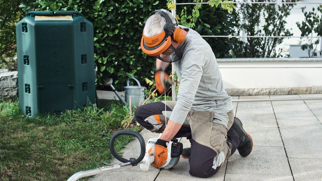 Osoba u zaštitnoj odeći povlači sajlu za pokretanje benzinske motorne kose STIHL FS 38