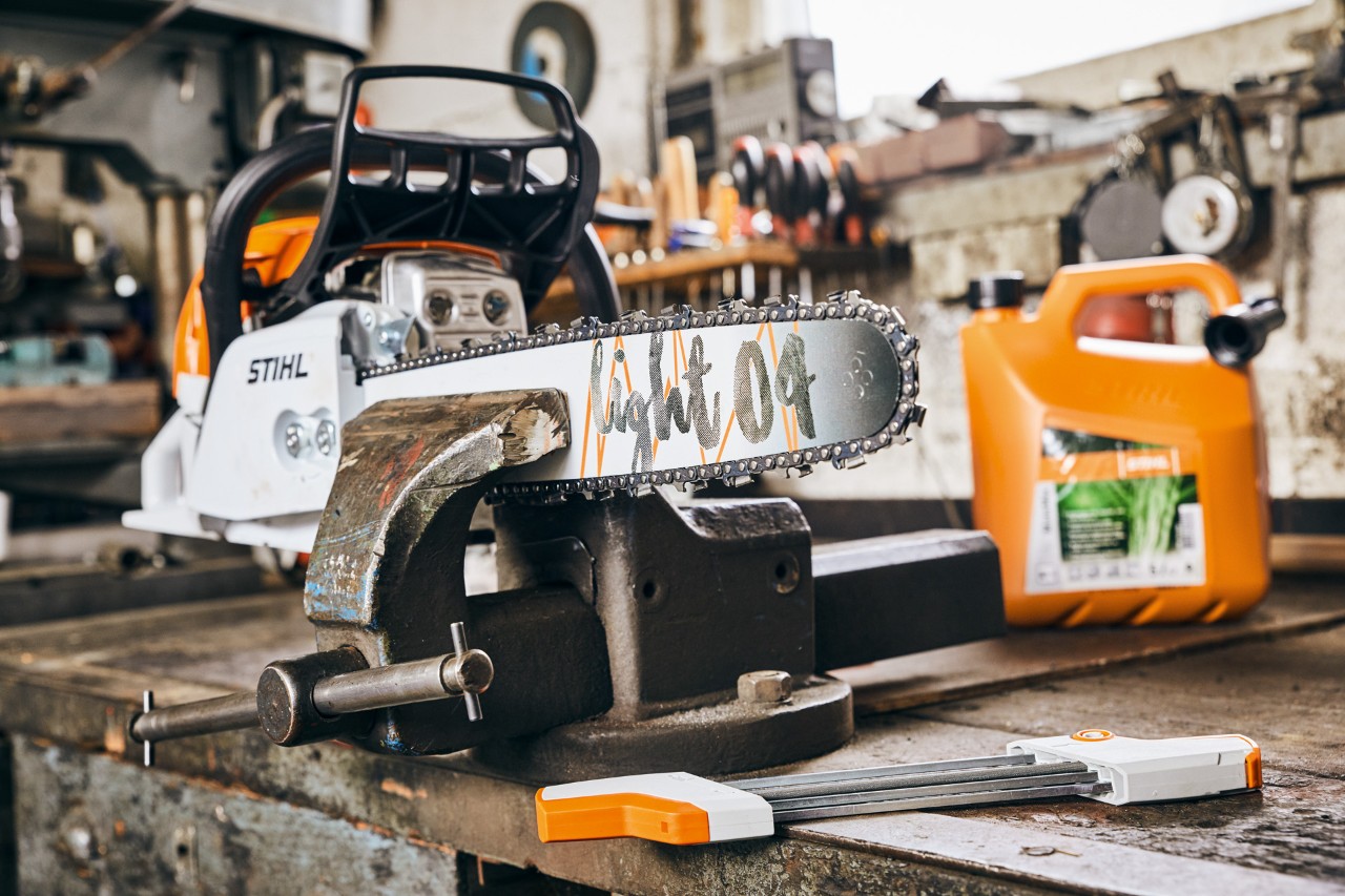 STIHL benzinska lančana testera MS 261 C-M sa vodećom šinom Light 04 pored STIHL mešavine goriva MotoMix pre oštrenja
