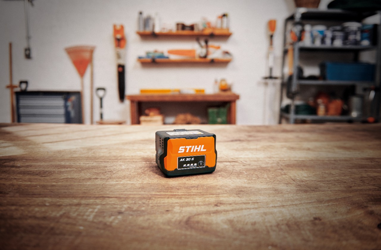 Radionica sa STIHL baterijom AK 30 S na drvenom stolu 