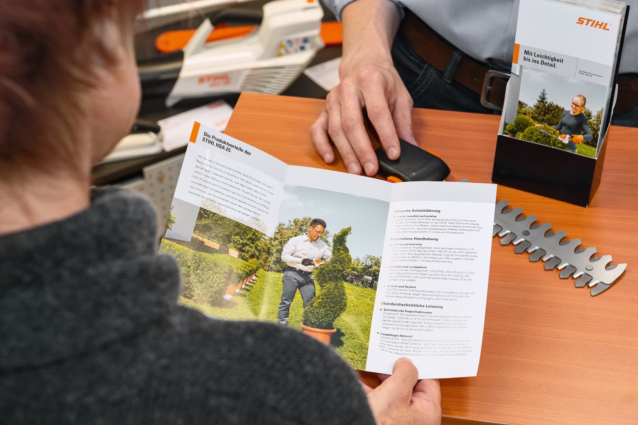 Osoba gleda prednosti proizvoda STIHL HSA 25 u prospektu