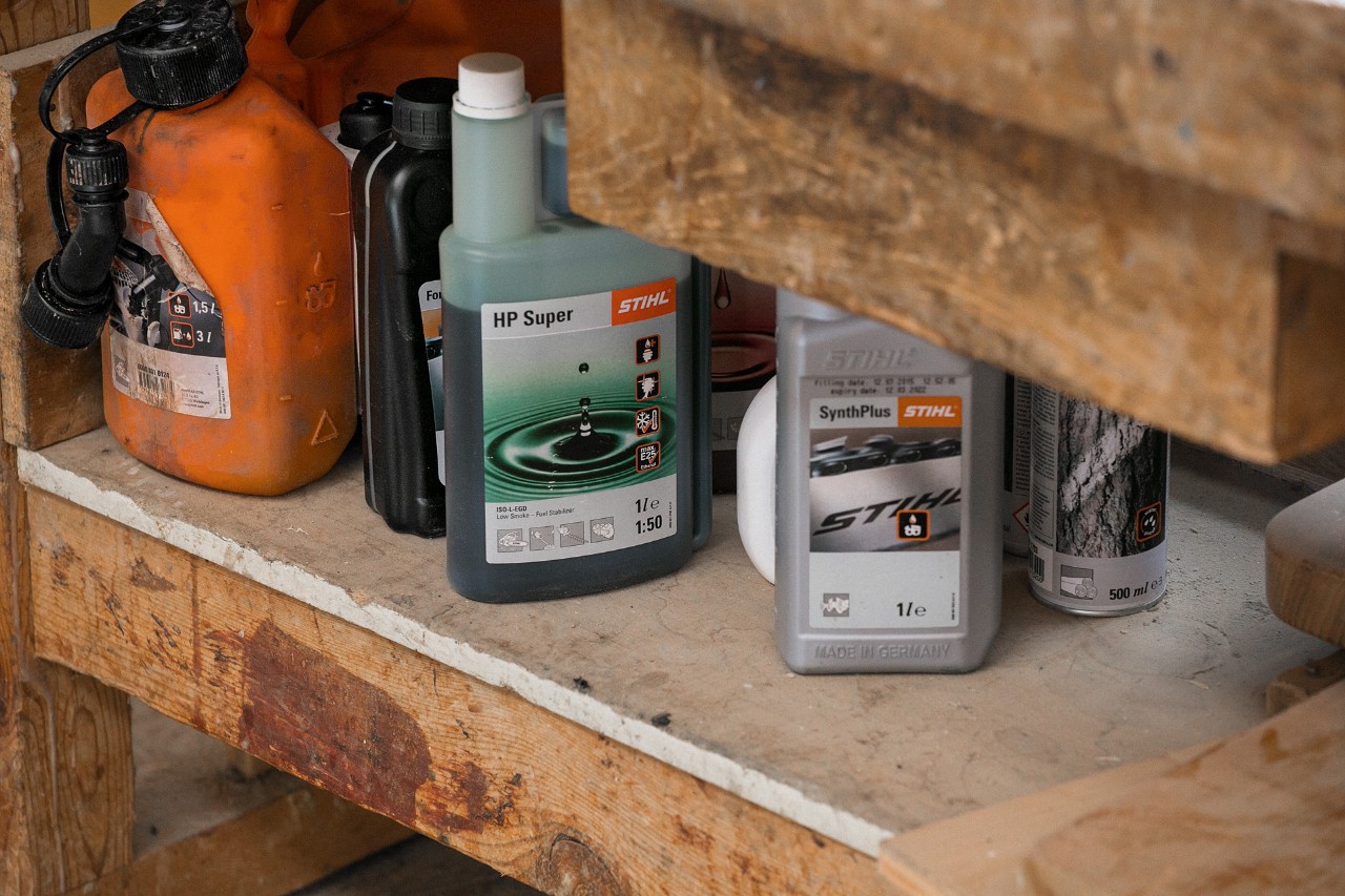STIHL ulje za lančane testere SynthPlus i STIHL ulje za dvotaktne motore HP Super pored drugih pogonskih sredstava na regalu
